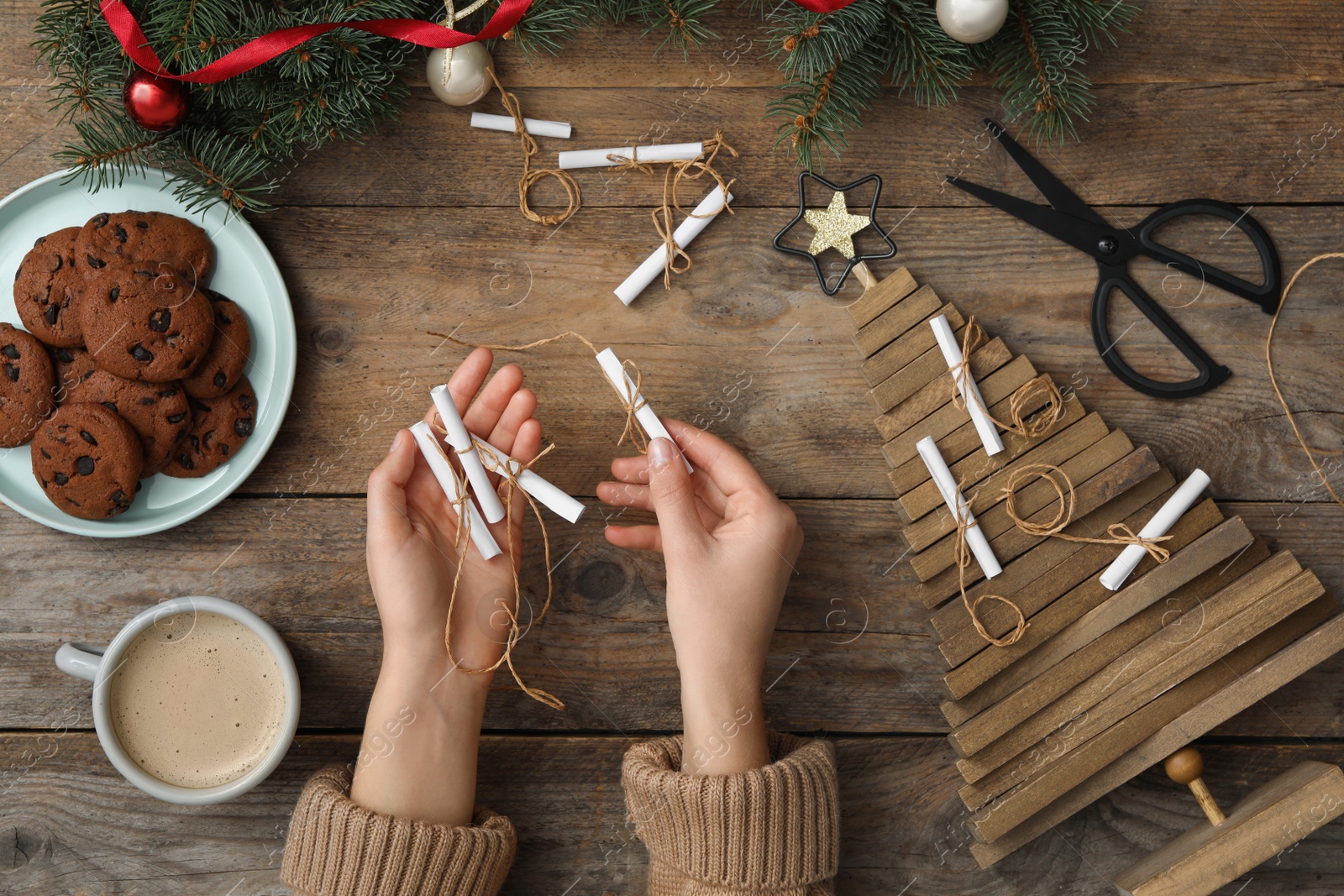 Woman making advent calendar at wooden table, top view Photo of Woman making advent calendar at wooden table, top view