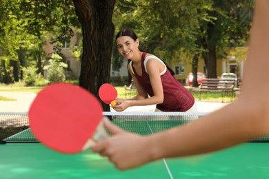 Young women playing ping pong in park Photo of Young women playing ping pong in park