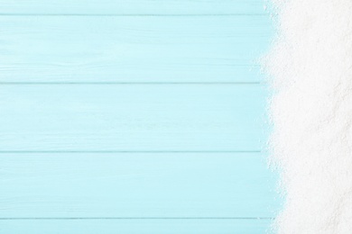 Artificial snow on light blue wooden background, top view with space for text. Christmas decor Photo of Artificial snow on light blue wooden background, top view with space for text. Christmas decor