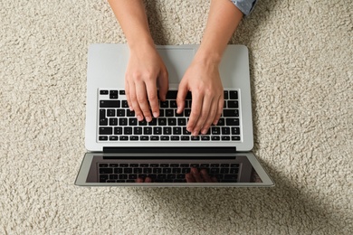 Young woman using laptop for search on floor, top view Photo of Young woman using laptop for search on floor, top view