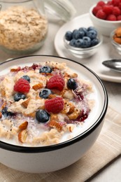 Photo of Tasty oatmeal porridge with toppings served on grey table, closeup