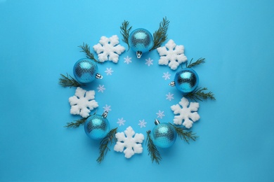 Bright festive wreath made of Christmas balls, decorative snowflakes and fir branches on light blue background, top view. Space for text Photo of Bright festive wreath made of Christmas balls, decorative snowflakes and fir branches on light blue background, top view. Space for text