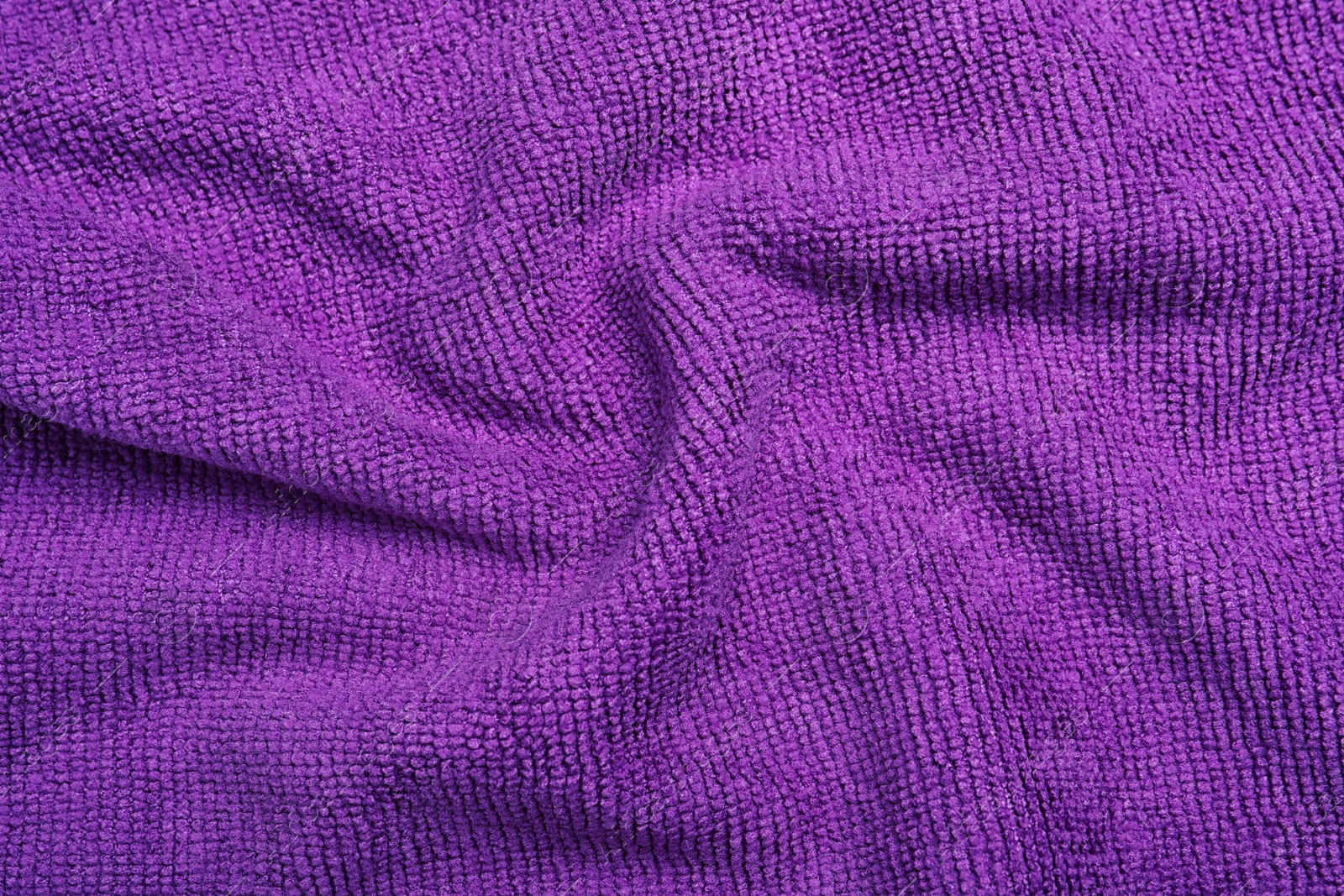 Crumpled purple microfiber cloth as background, closeup Photo of Crumpled purple microfiber cloth as background, closeup