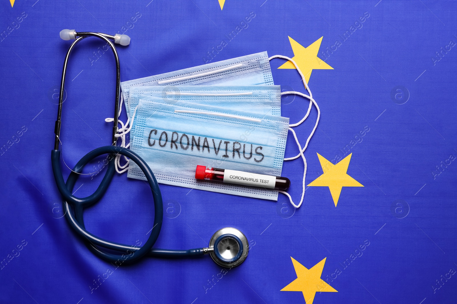 Stethoscope, protective masks and test tube with blood sample on European Union flag background, flat lay. Coronavirus outbreak Photo of Stethoscope, protective masks and test tube with blood sample on European Union flag background, flat lay. Coronavirus outbreak