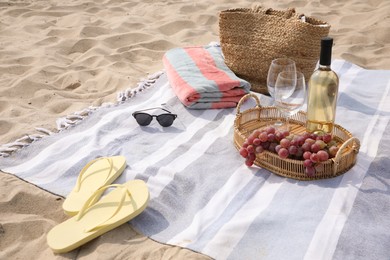 Bag, blanket, wine and other stuff for beach picnic on sand Photo of Bag, blanket, wine and other stuff for beach picnic on sand