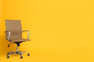Modern office chair on yellow background. Space for text Photo of Modern office chair on yellow background. Space for text