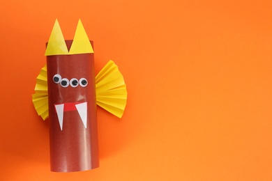 Funny brown monster on orange background, top view with space for text. Halloween decoration Photo of Funny brown monster on orange background, top view with space for text. Halloween decoration