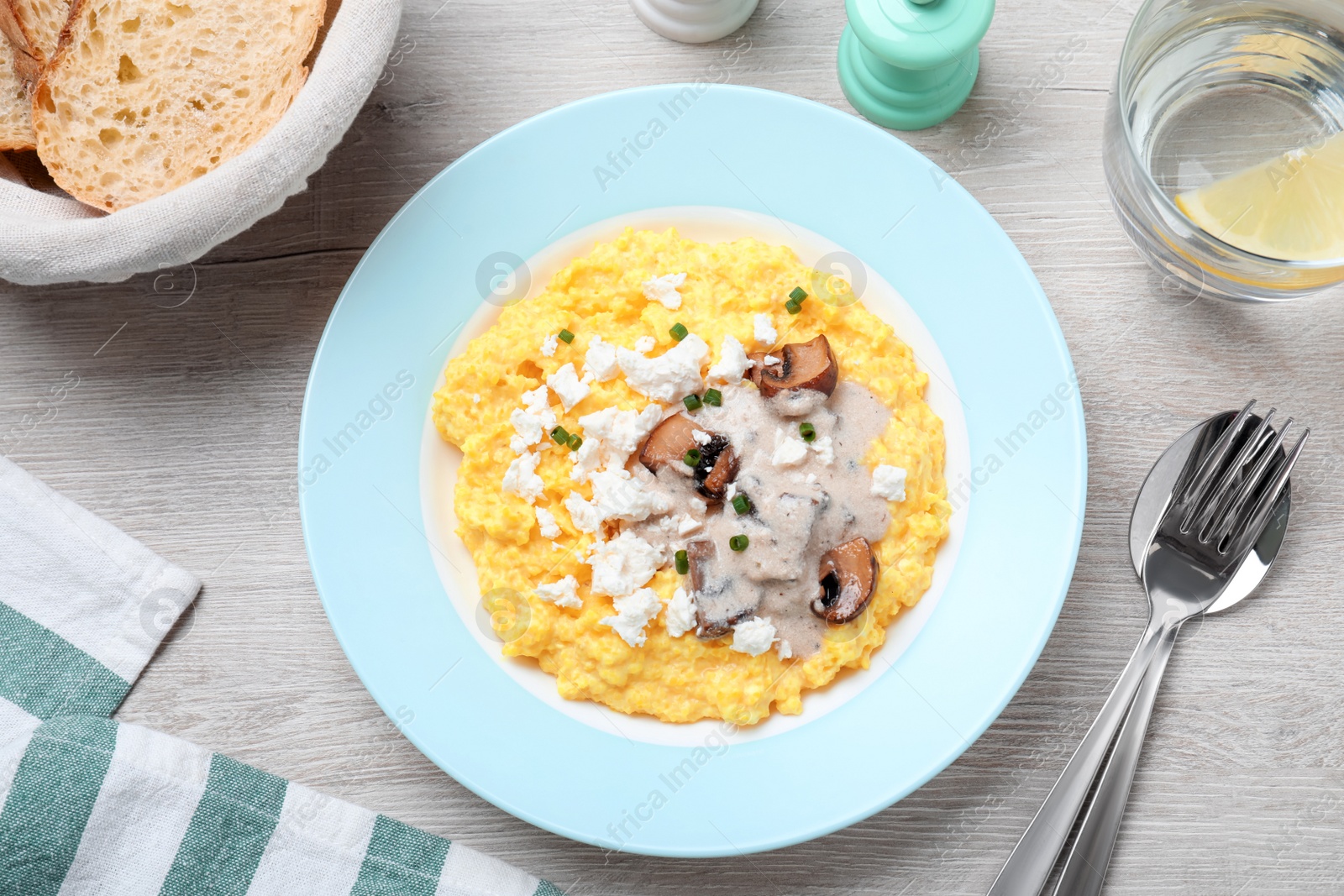 Tasty banosh served with brynza and mushrooms on light wooden table, flat lay. Traditional Ukrainian dish Photo of Tasty banosh served with brynza and mushrooms on light wooden table, flat lay. Traditional Ukrainian dish