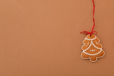 Christmas tree shaped cookie on brown background, top view. Space for text Photo of Christmas tree shaped cookie on brown background, top view. Space for text