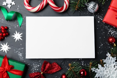 Photo of Flat lay composition with Christmas decor and blank card on black background. Space for text
