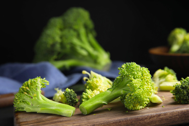 Photo of Raw green broccoli on wooden cutting board