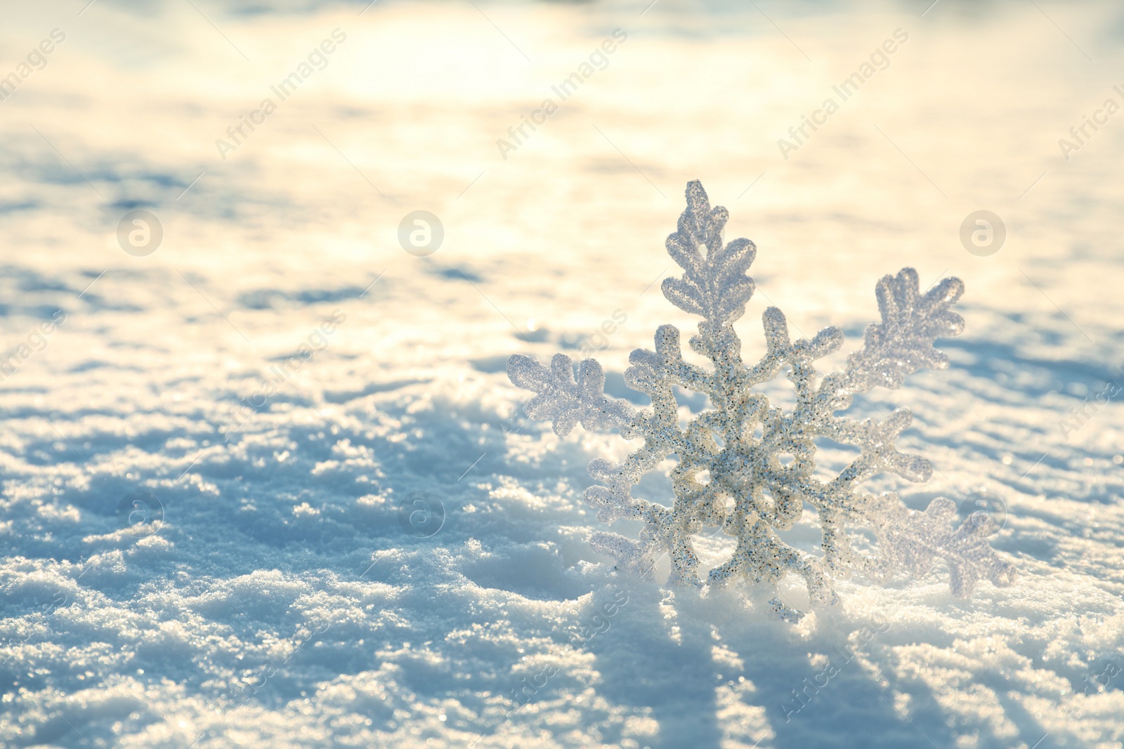 Beautiful decorative snowflake in white snow, outdoors. Space for text Photo of Beautiful decorative snowflake in white snow, outdoors. Space for text