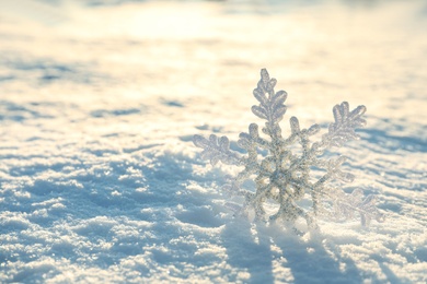 Beautiful decorative snowflake in white snow, outdoors. Space for text Photo of Beautiful decorative snowflake in white snow, outdoors. Space for text