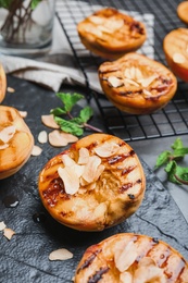 Delicious grilled peaches with almond flakes on slate plate, closeup Photo of Delicious grilled peaches with almond flakes on slate plate, closeup