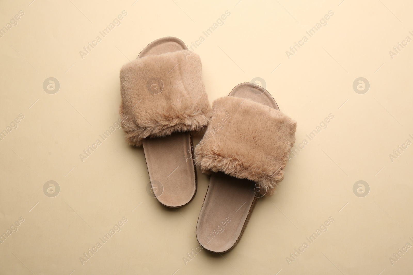 Pair of soft slippers on beige background, flat lay Photo of Pair of soft slippers on beige background, flat lay