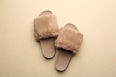Pair of soft slippers on beige background, flat lay Photo of Pair of soft slippers on beige background, flat lay