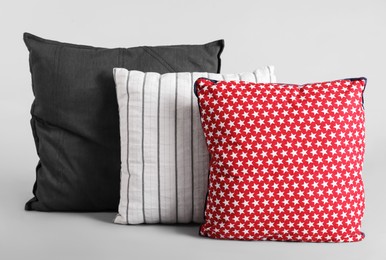 Different stylish soft pillows on grey background Photo of Different stylish soft pillows on grey background