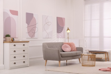 Stylish living room interior with comfortable sofa and beautiful pictures Photo of Stylish living room interior with comfortable sofa and beautiful pictures