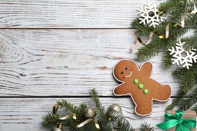 Photo of Flat lay composition with gingerbread man on white wooden table, space for text