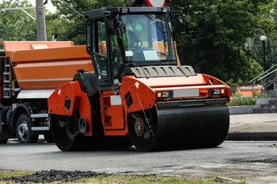 Road repair machinery working on city street Photo of Road repair machinery working on city street