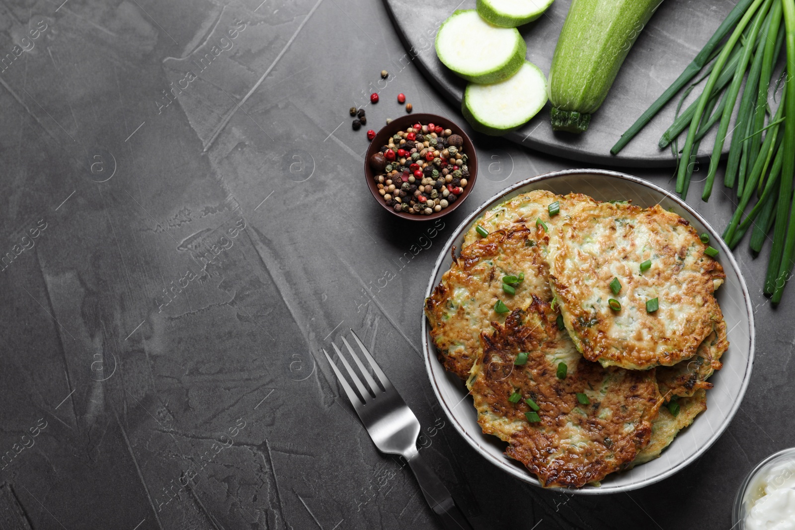 Delicious zucchini fritters served on grey table, flat lay. Space for text Photo of Delicious zucchini fritters served on grey table, flat lay. Space for text