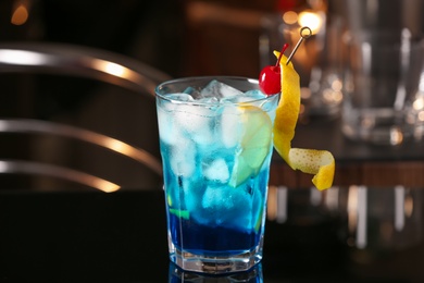 Photo of Blue Lagoon cocktail on black table in bar