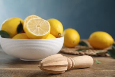 Squeezer with lemons on wooden table, closeup Photo of Squeezer with lemons on wooden table, closeup