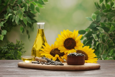 Composition with sunflower oil on wooden table against blurred background Photo of Composition with sunflower oil on wooden table against blurred background