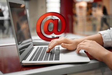 Woman sending email via laptop in cafe, closeup Image of Woman sending email via laptop in cafe, closeup