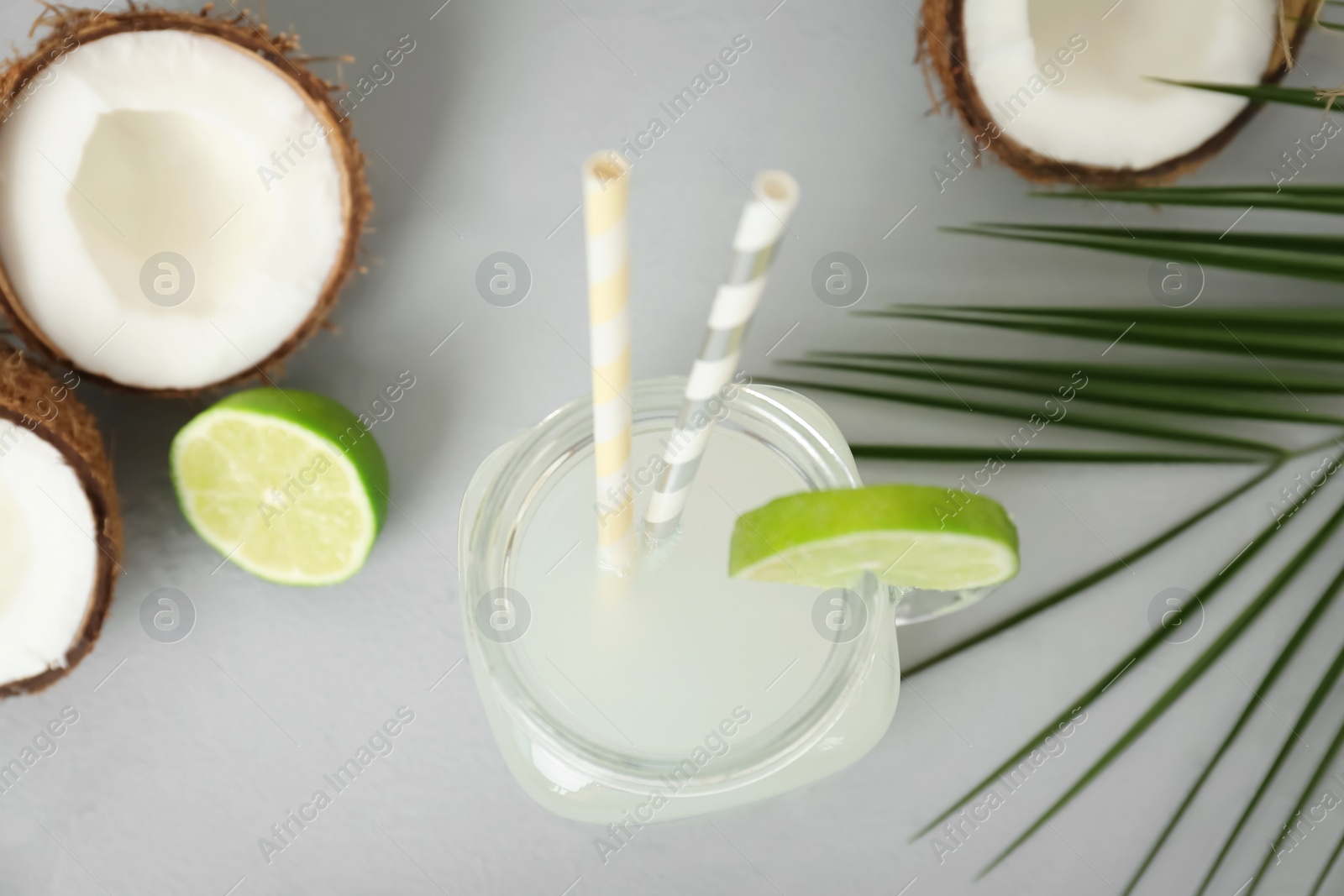 Mason jar with coconut water and fresh nuts on grey background, top view Photo of Mason jar with coconut water and fresh nuts on grey background, top view