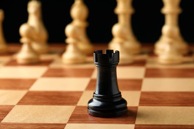 Chessboard with game pieces on black background Photo of Chessboard with game pieces on black background