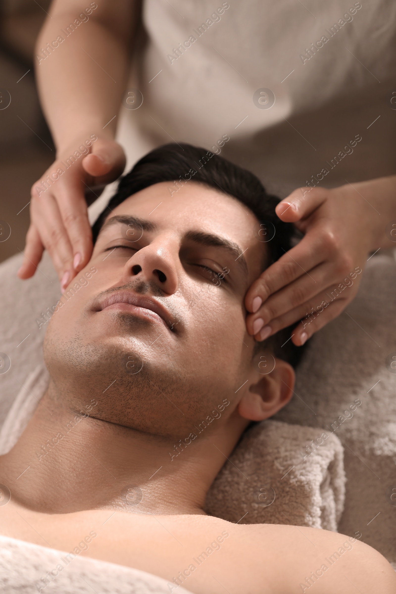 Man receiving facial massage in beauty salon Photo of Man receiving facial massage in beauty salon