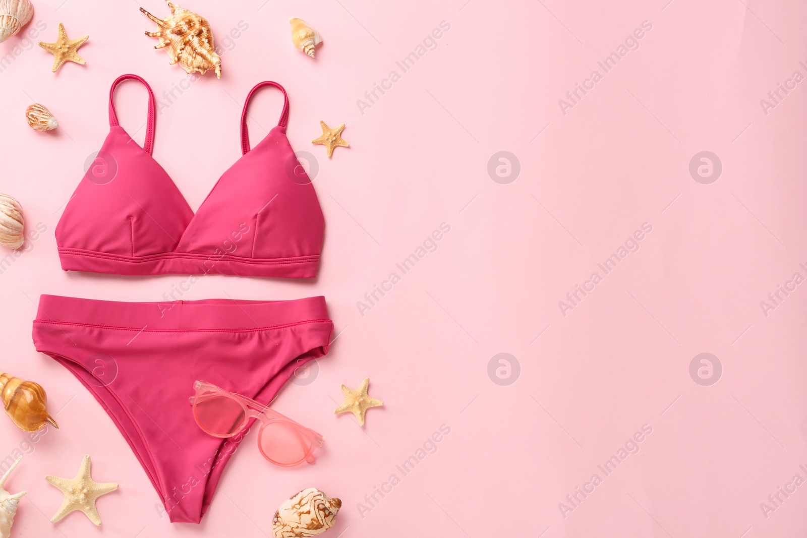 Stylish bikini and beach accessories on pink background, flat lay. Space for text Photo of Stylish bikini and beach accessories on pink background, flat lay. Space for text
