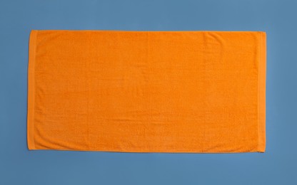 Orange beach towel on blue background, top view Photo of Orange beach towel on blue background, top view