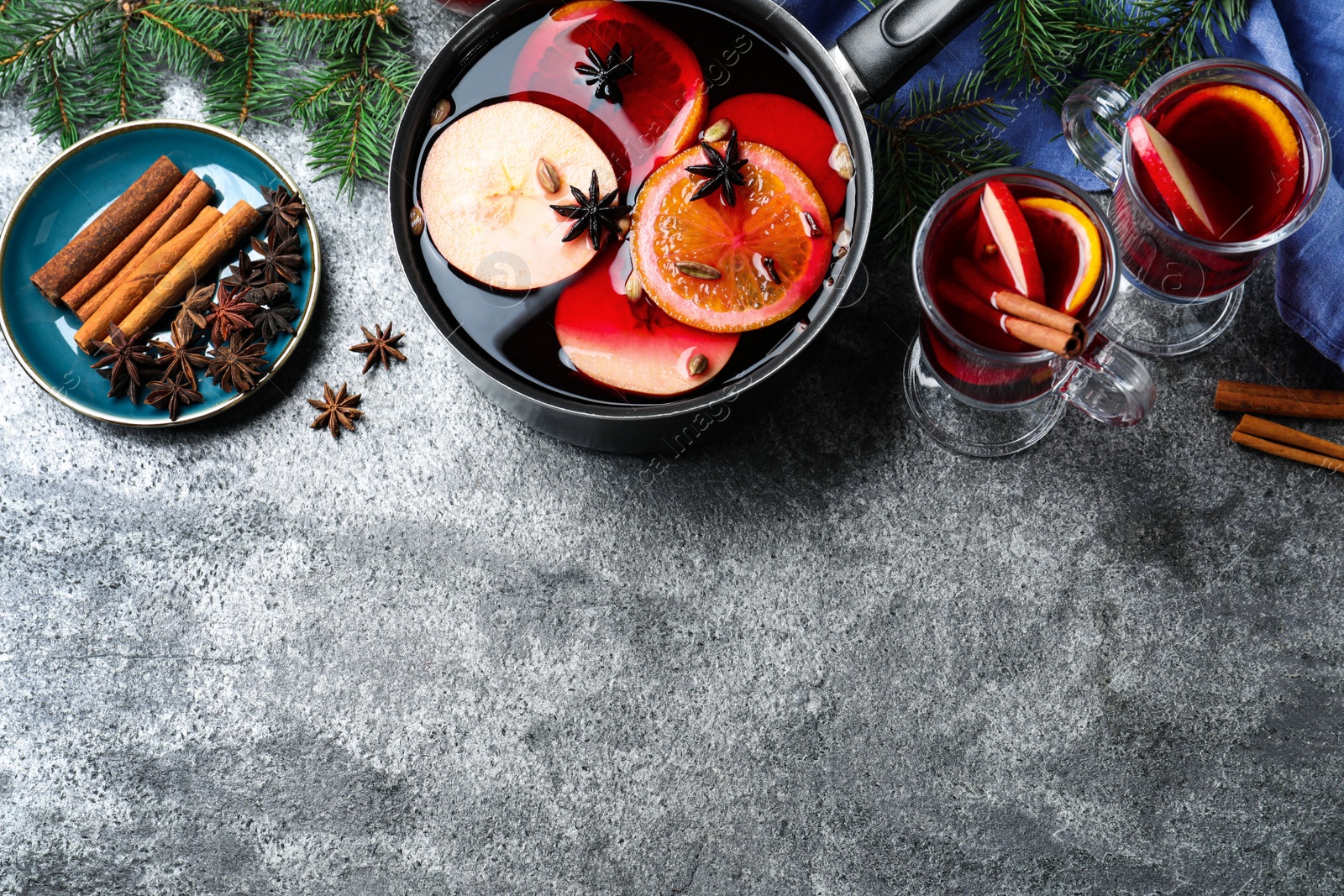 Delicious mulled wine and ingredients on grey table, flat lay. Space for text Photo of Delicious mulled wine and ingredients on grey table, flat lay. Space for text