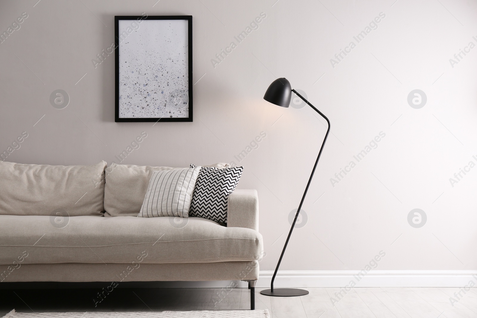 Stylish living room interior with comfortable sofa and floor lamp. Space for text Photo of Stylish living room interior with comfortable sofa and floor lamp. Space for text