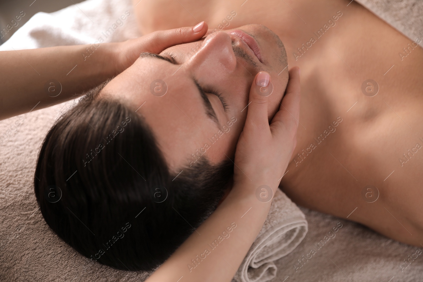 Man receiving facial massage in beauty salon, closeup Photo of Man receiving facial massage in beauty salon, closeup