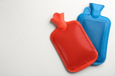 Rubber hot water bottles on white background, top view Photo of Rubber hot water bottles on white background, top view