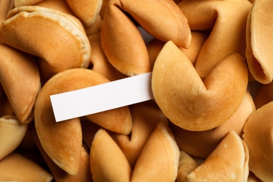 Paper with prediction on pile of fortune cookies, closeup Photo of Paper with prediction on pile of fortune cookies, closeup
