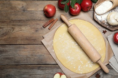 Flat lay composition with raw dough and ingredients on wooden table, space for text. Baking apple pie Photo of Flat lay composition with raw dough and ingredients on wooden table, space for text. Baking apple pie