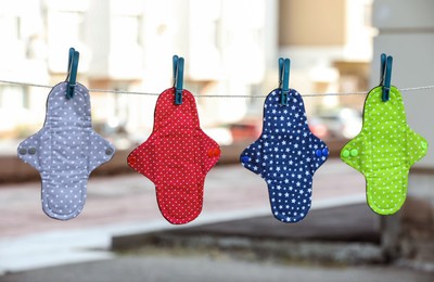 Many different menstrual cloth pads hanging on rope outdoors Photo of Many different menstrual cloth pads hanging on rope outdoors