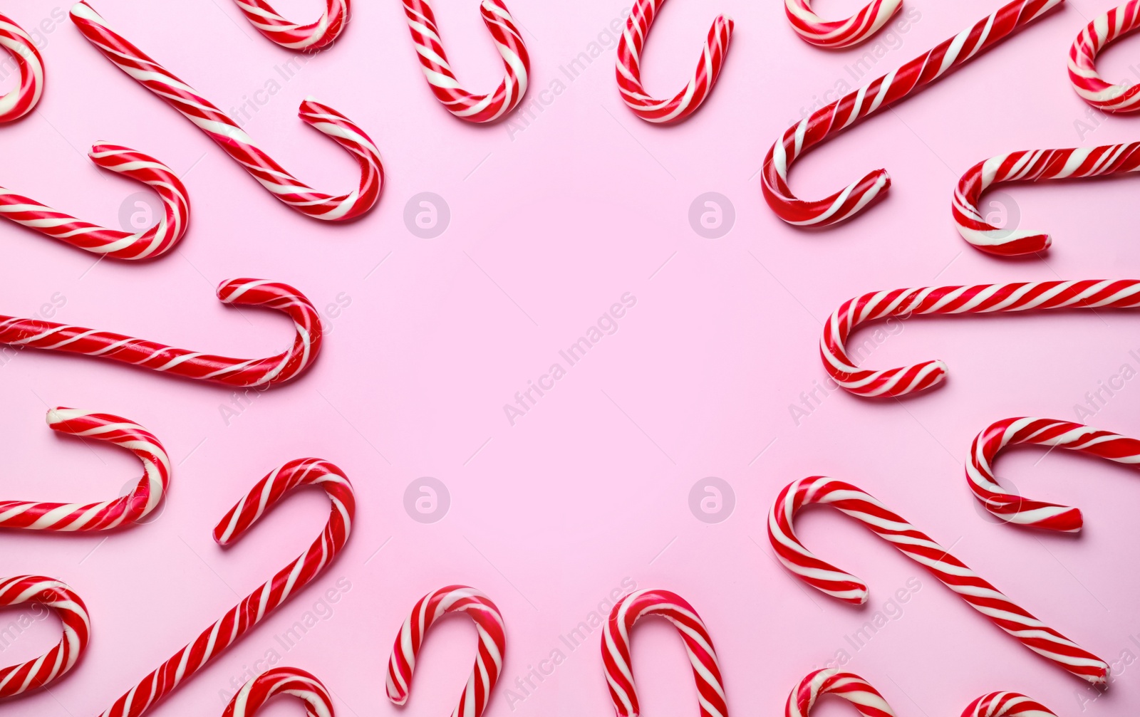 Sweet Christmas candy canes on pink background, flat lay. Space for text Photo of Sweet Christmas candy canes on pink background, flat lay. Space for text