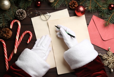 Top view of Santa writing letter at wooden table, closeup Photo of Top view of Santa writing letter at wooden table, closeup