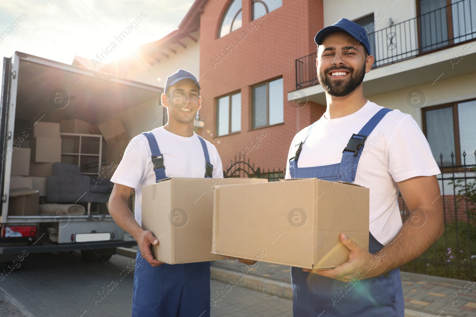 Workers unloading boxes from van outdoors. Moving service Photo of Workers unloading boxes from van outdoors. Moving service