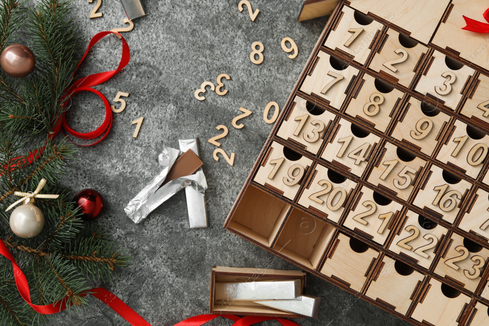 Flat lay composition with wooden advent calendar and Christmas decor on grey background Photo of Flat lay composition with wooden advent calendar and Christmas decor on grey background