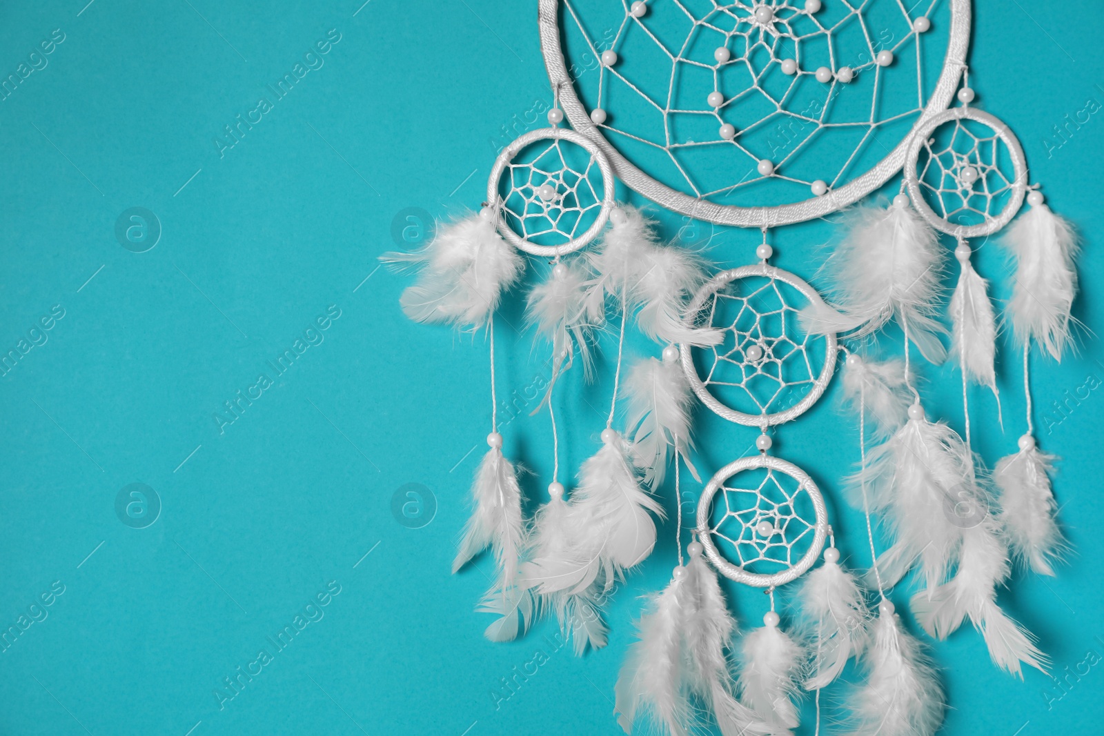 Beautiful dream catcher hanging on light blue background. Space for text Photo of Beautiful dream catcher hanging on light blue background. Space for text