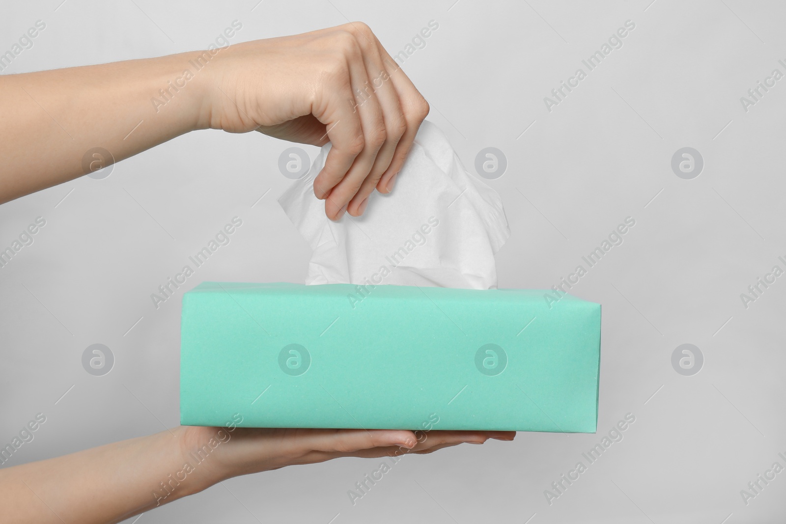 Woman taking paper tissue from box on light background, closeup Photo of Woman taking paper tissue from box on light background, closeup