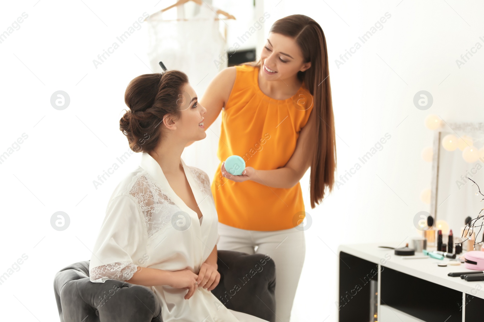 Makeup artist preparing bride before her wedding in room Photo of Makeup artist preparing bride before her wedding in room