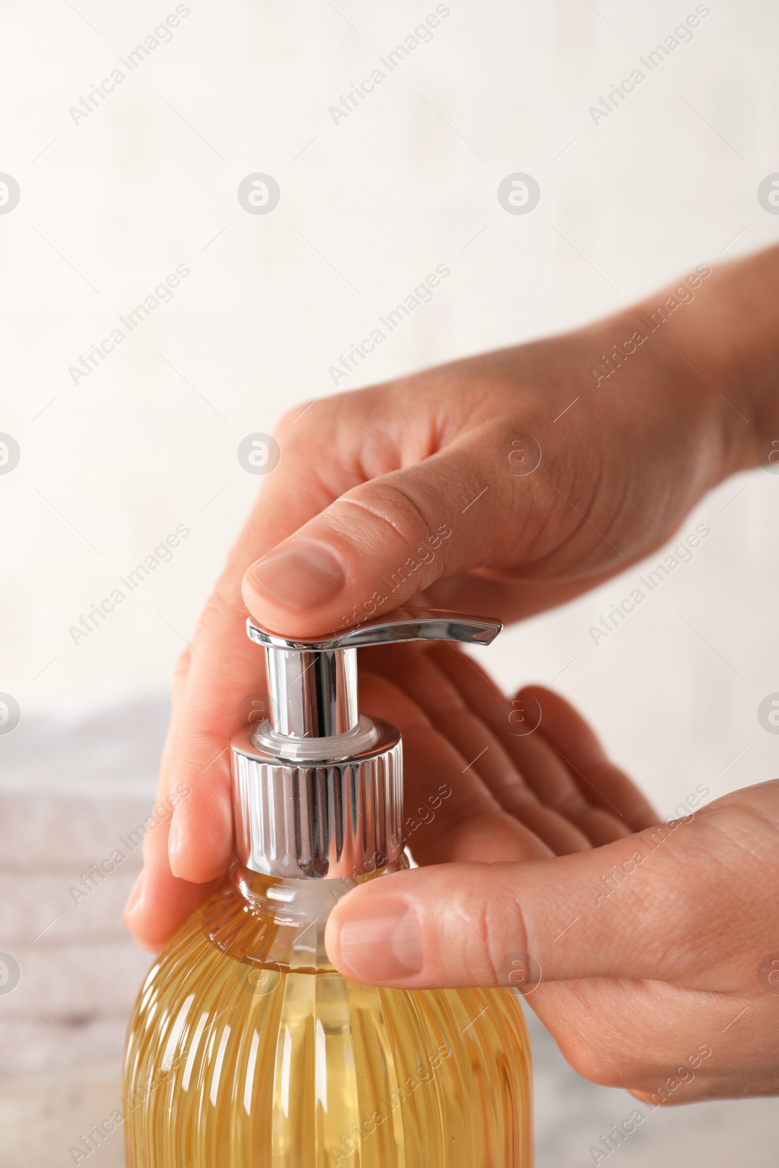 Woman using liquid soap dispenser, closeup view Photo of Woman using liquid soap dispenser, closeup view