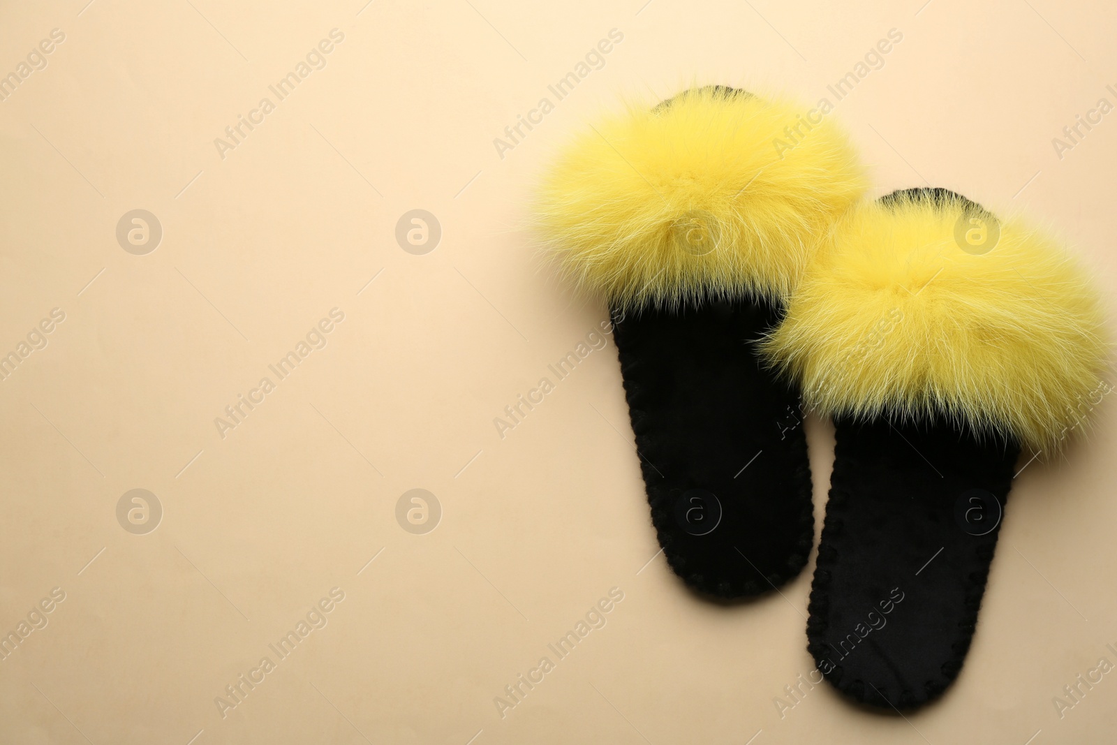 Pair of soft slippers on beige background, flat lay. Space for text Photo of Pair of soft slippers on beige background, flat lay. Space for text